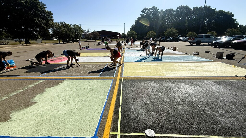Seniors painting on the ground in parking lo