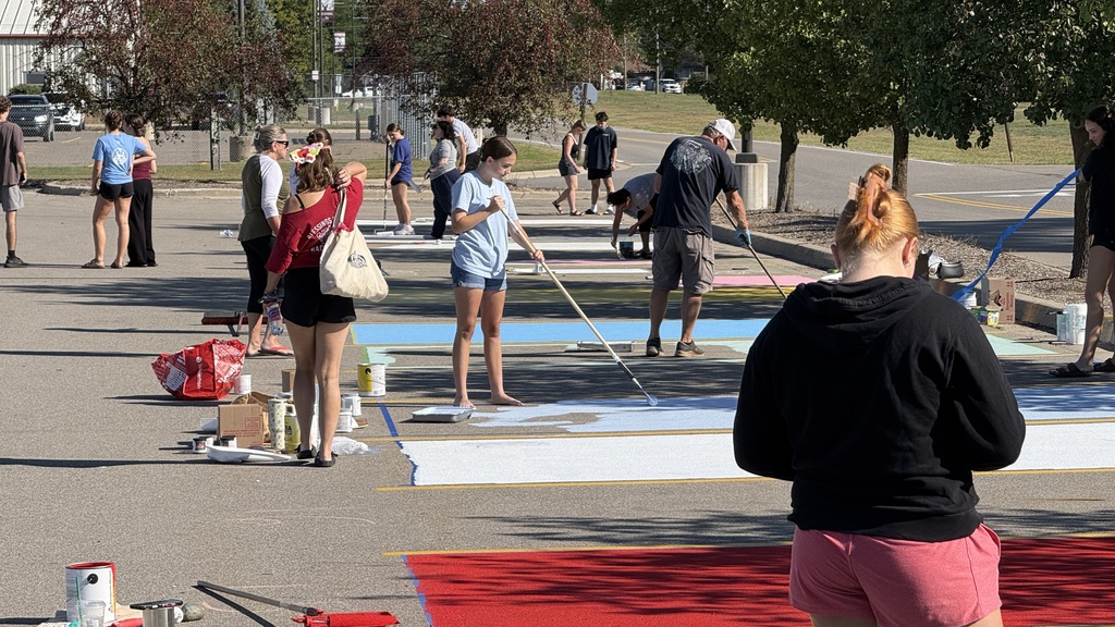 Seniors painting on the ground in parking lo