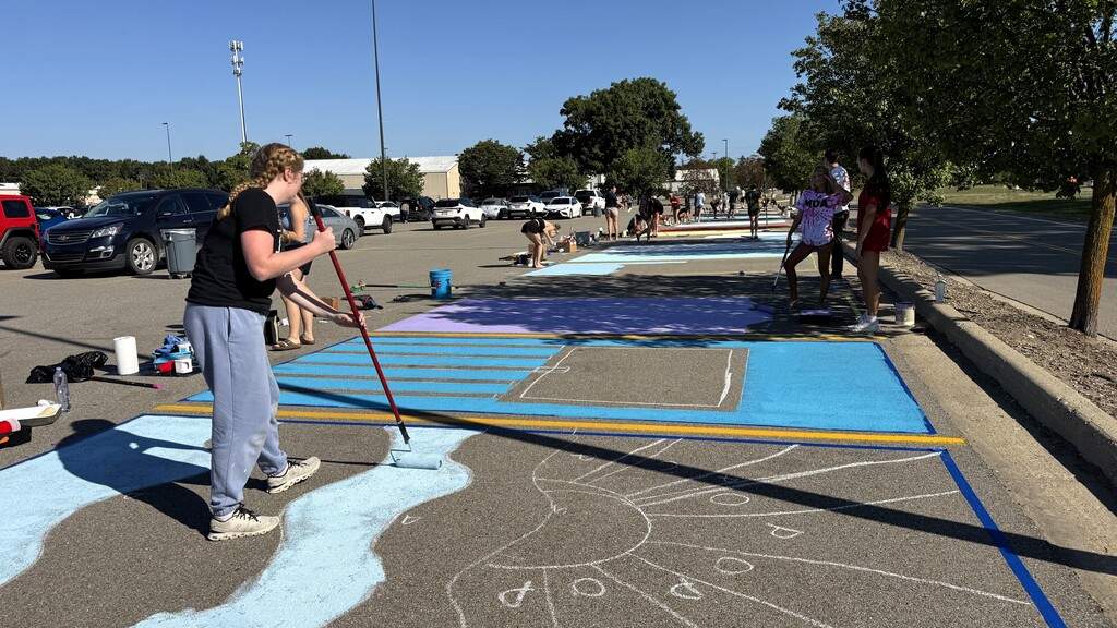 Senior girls painting on the ground in parking lo