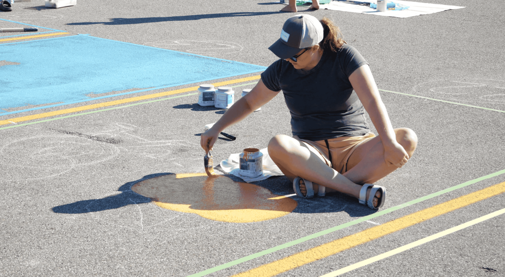 Senior girl painting on the ground in parking lot