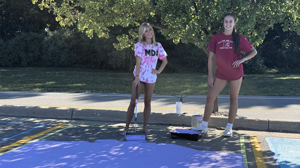 Senior girls painting on the ground in parking lo