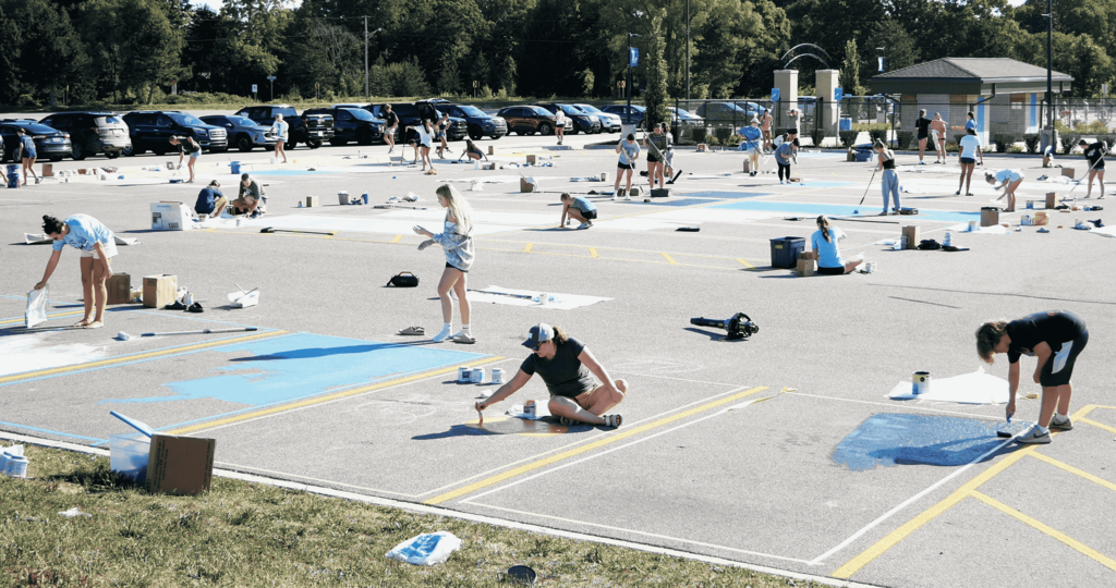 Senior painting on the ground in parking lot