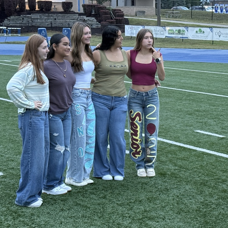 dozens of students gathering on football field  