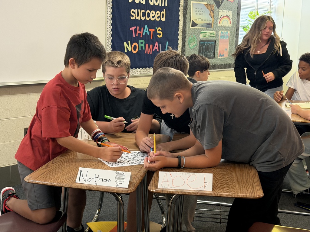 Students work as a group to solve a puzzle on their desks.