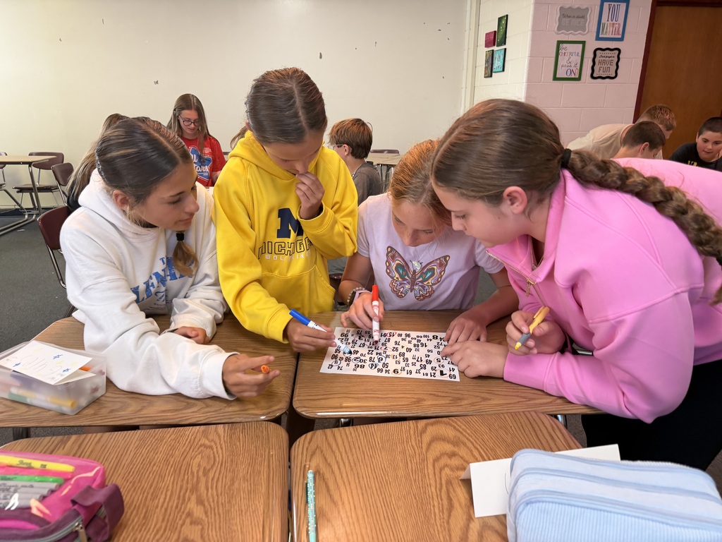 Students work as a group to solve a puzzle on their desks.