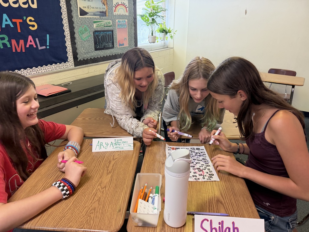 Students work as a group to solve a puzzle on their desks.