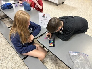 students sitting at cafeteria tables playing games