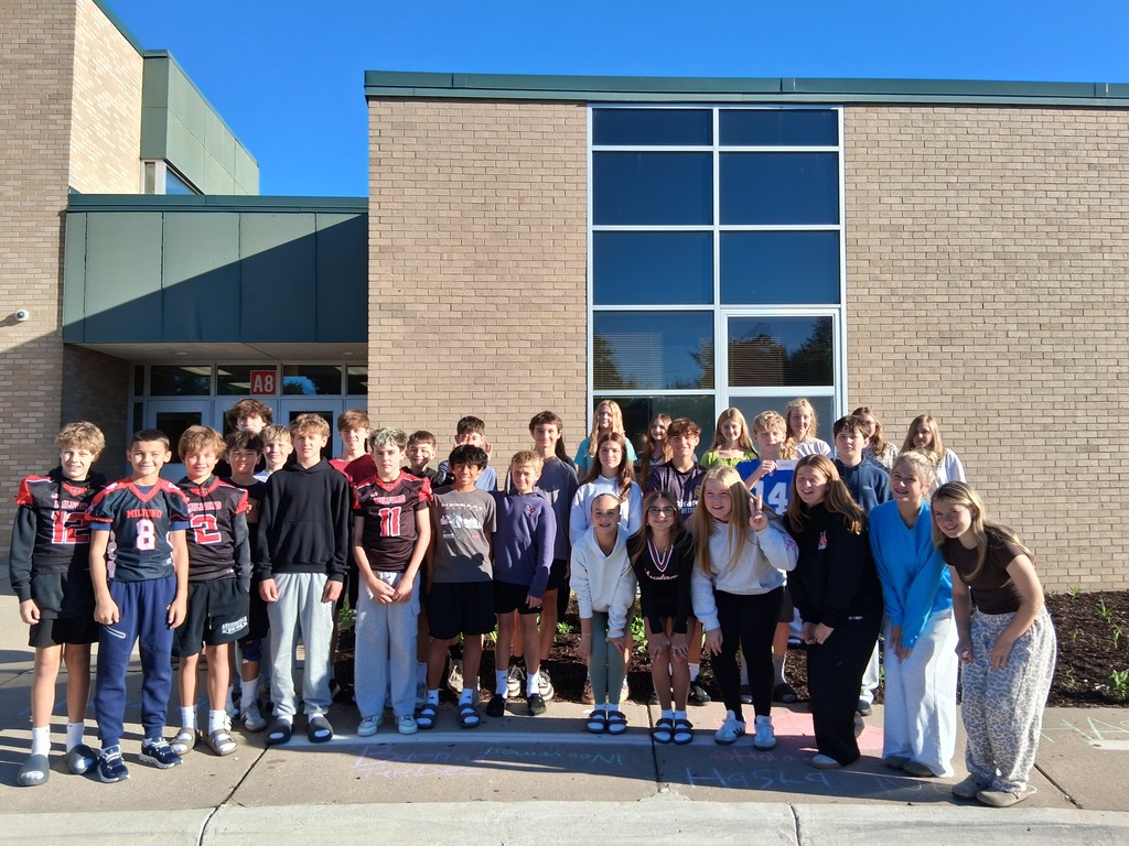 A group of students standing outside the school