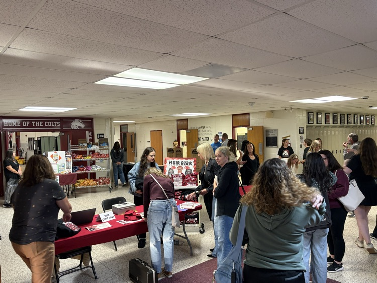 families are welcomed by students and staff at tables in the front of Muir