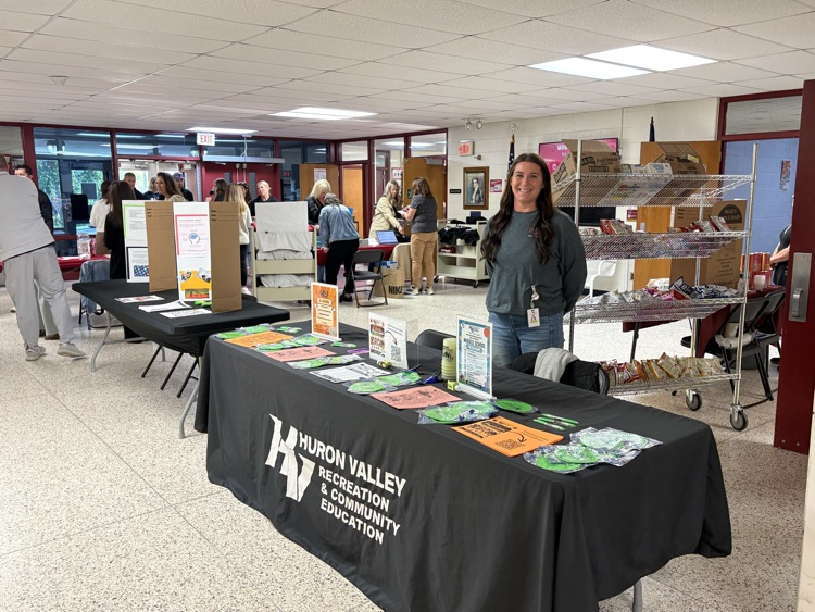 representatives from Huron valley rec and ed have colorful flyers on a table