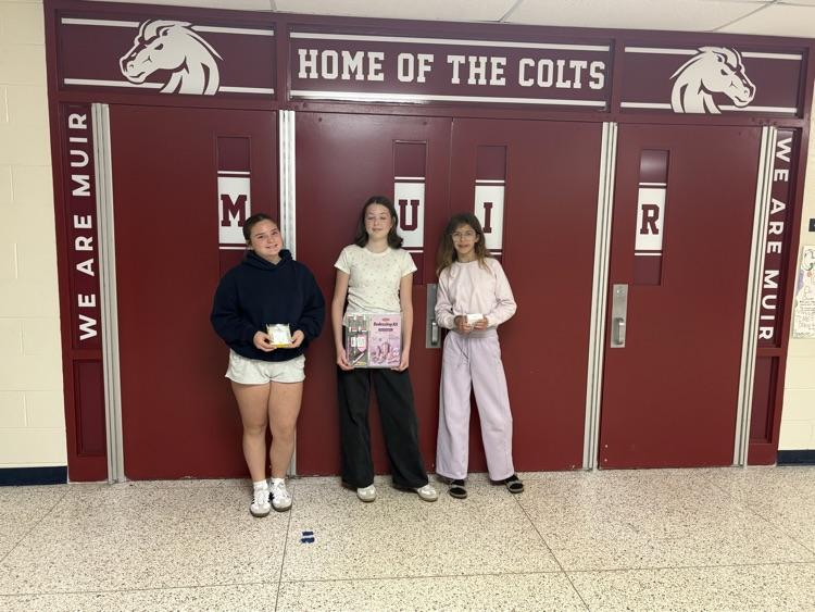 Three students stand with prizes from fundraiser.