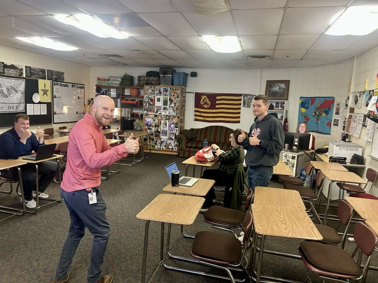 teachers gather with their thumbs up