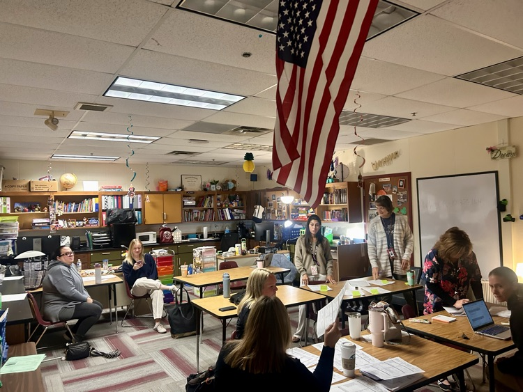 a room full of teachers meet with papers and sticky notes