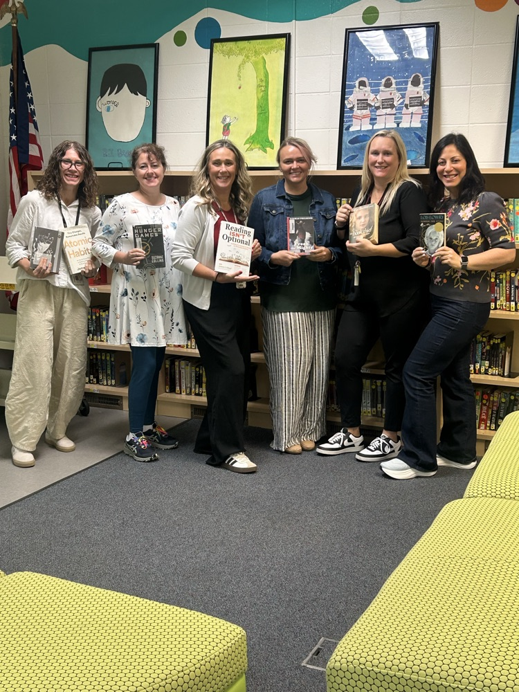 6 teachers stand holding books