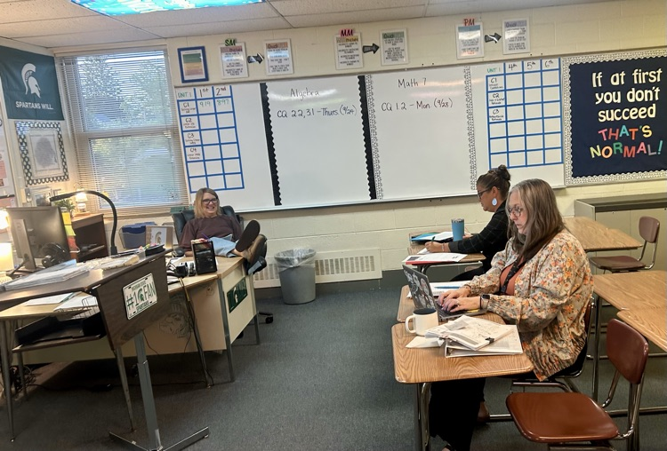 3 teachers sit with laptops 