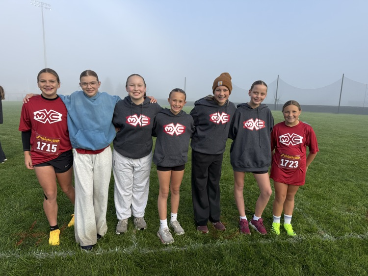student runners stand together before the race in sweatshirts and jerseys 