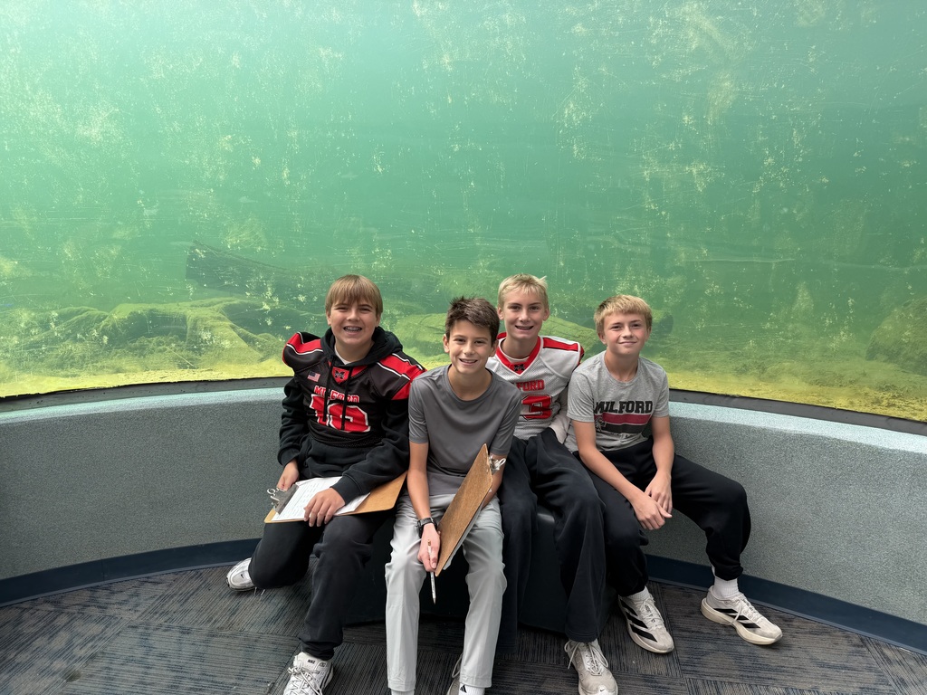 four students gather under a pond observation dome