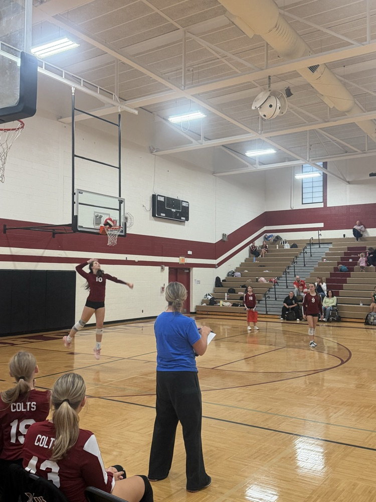 Muir player serves the volleyball