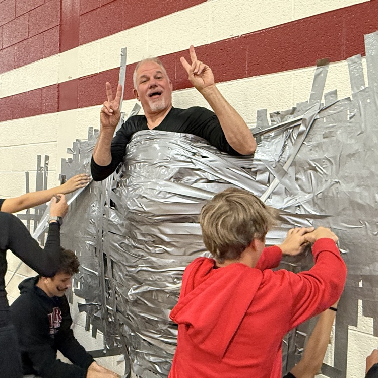 man being taped to the wall