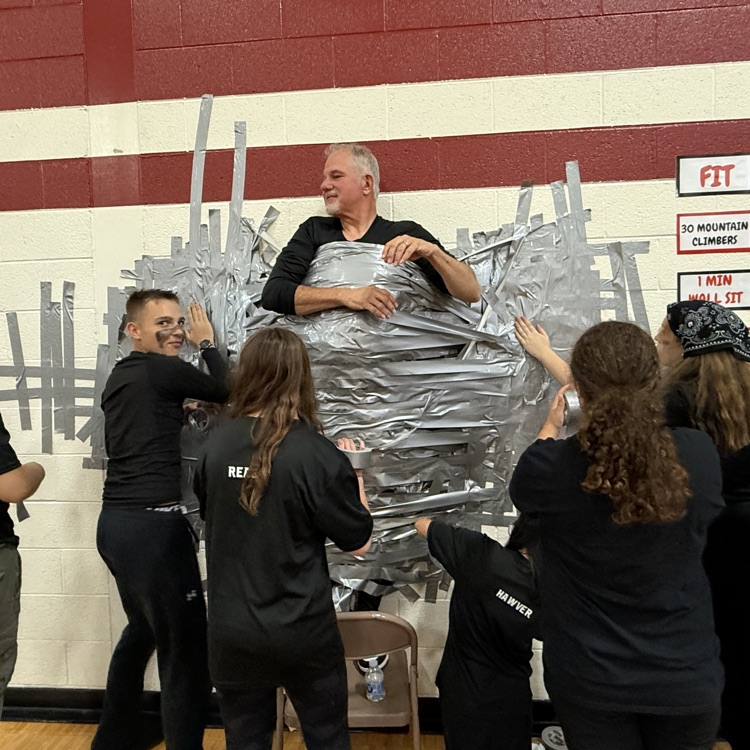 man being taped to the wall by students