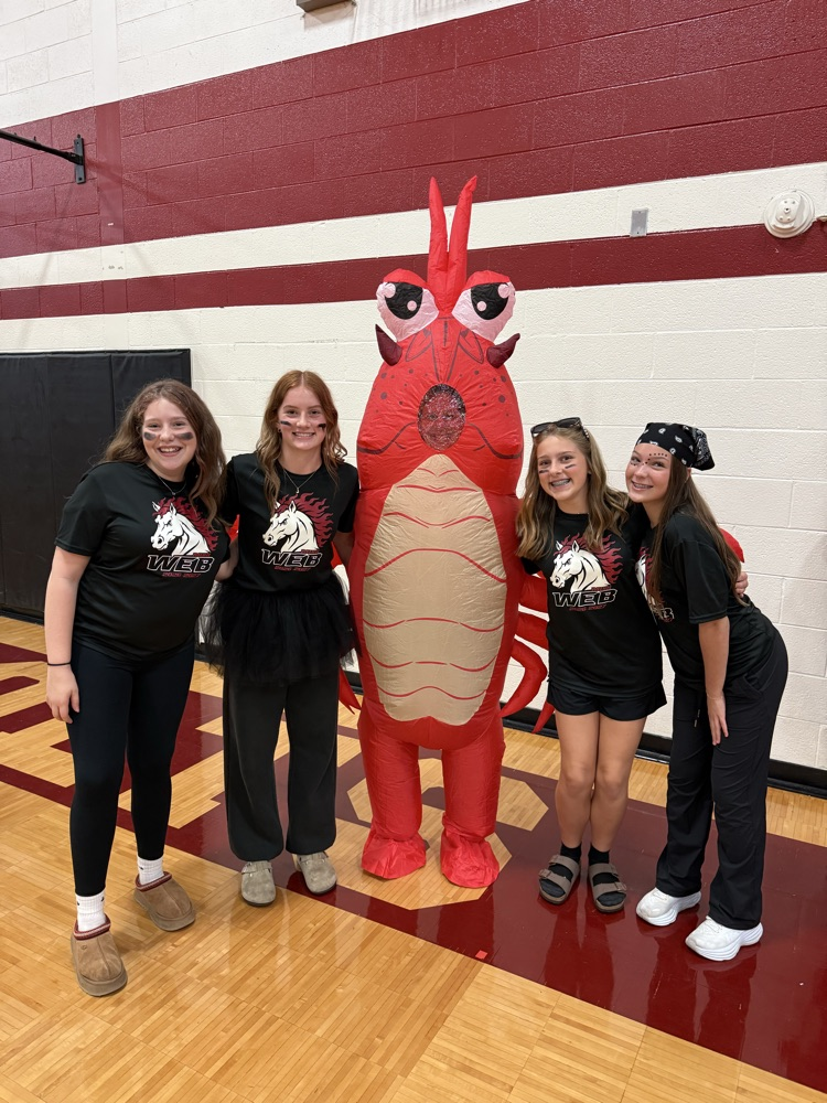 4 students stand with a lobster costume
