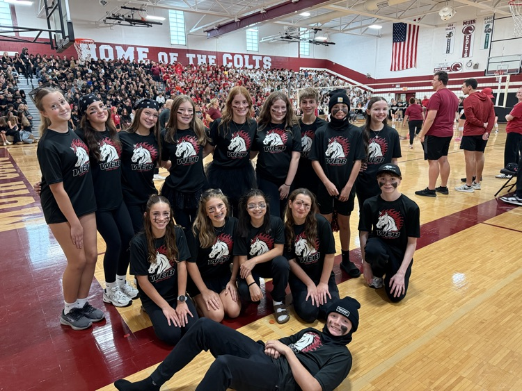 a group of students gather wearing school colors of red and black