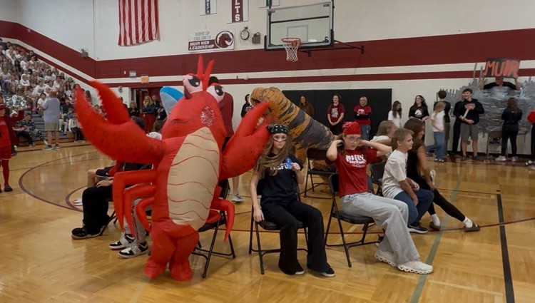 students and a lobster costume play musical chairs
