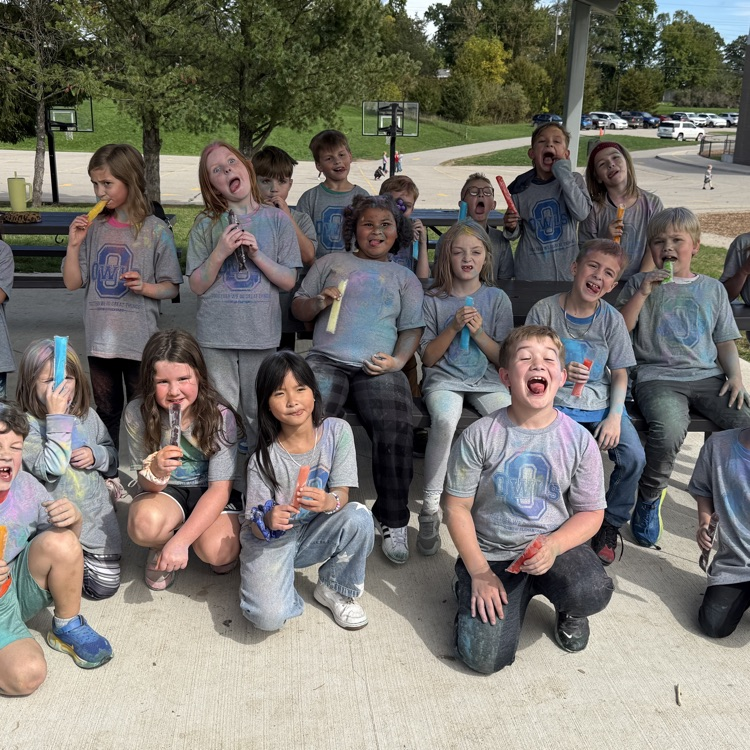 students pose for photo with color powder all over them