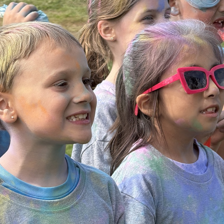 students pose for photo with color powder all over them