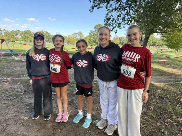 group of 5 cross country runners stand outside 