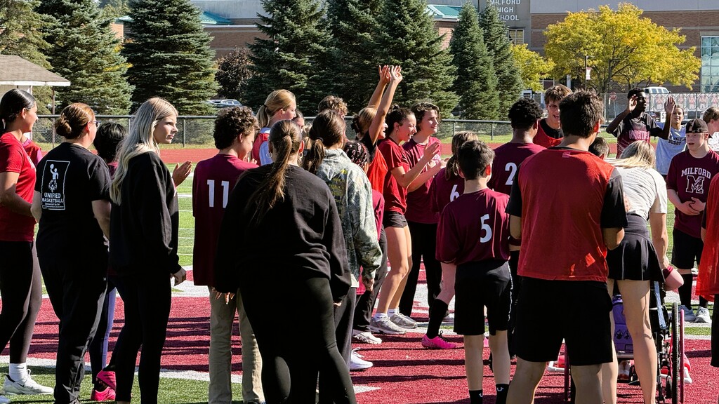 Several soccer players dancing on the middle of a field 