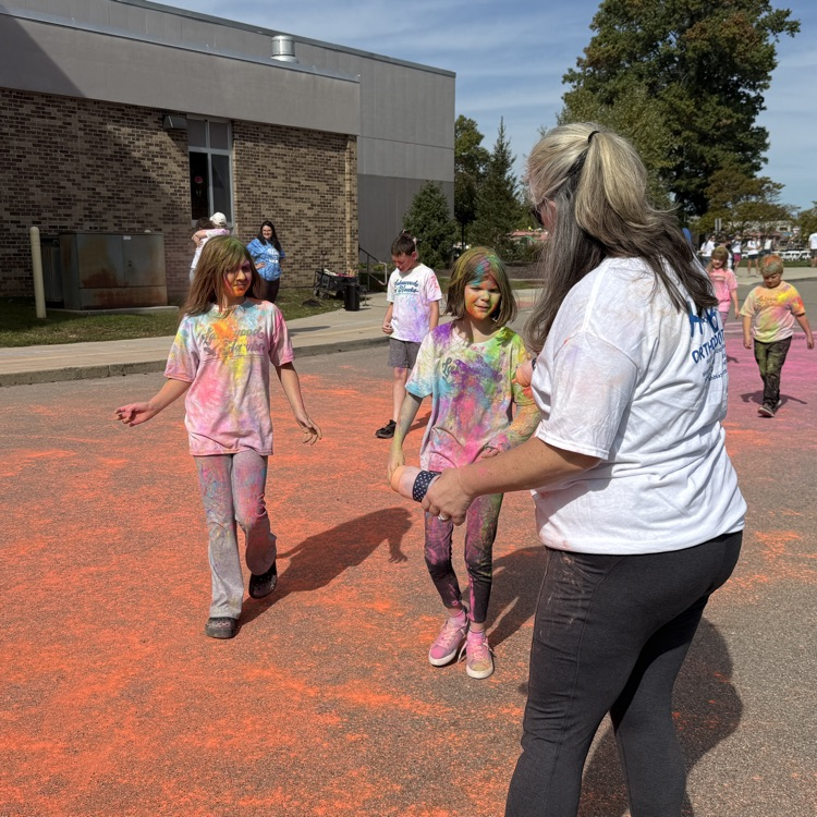 school kids covered in colored powder walking outside