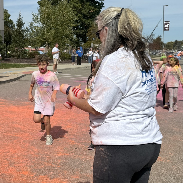 school kids covered in colored powder walking outside
