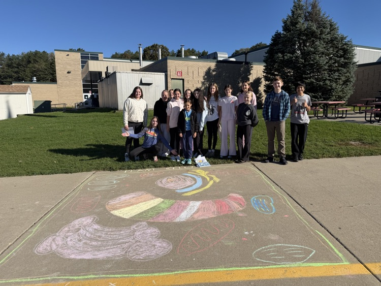 students stand near their chalk drawing outside Muir