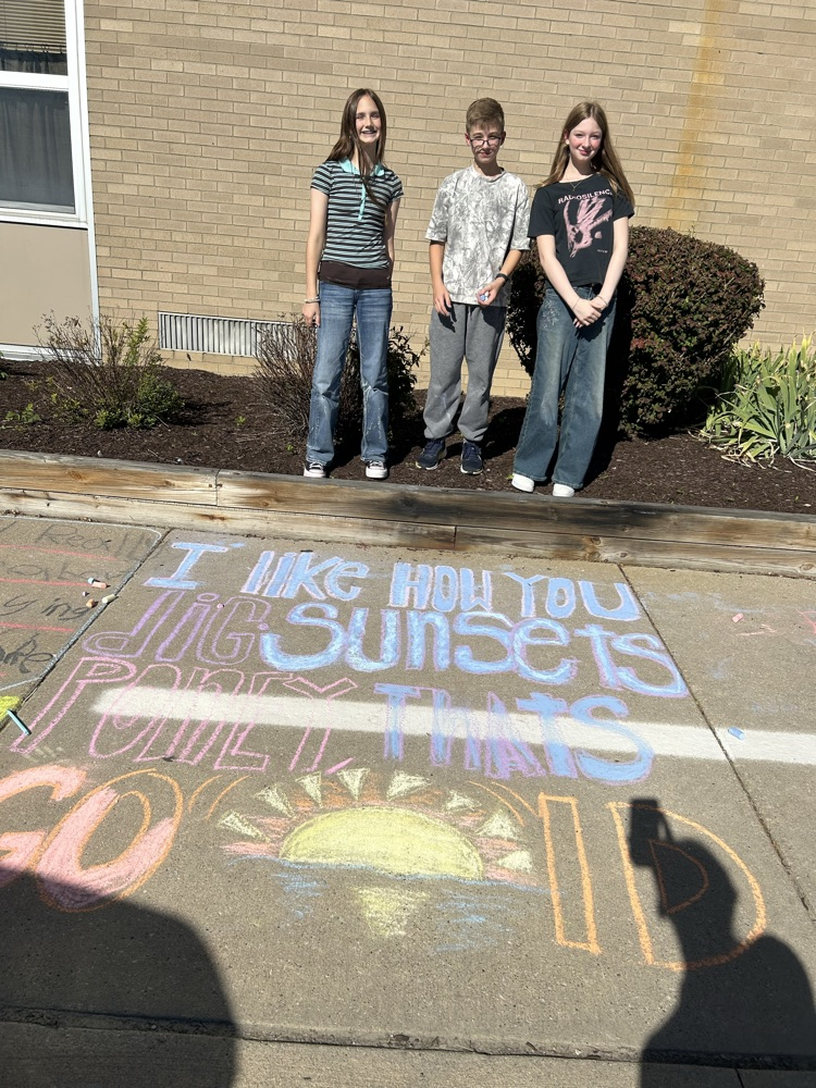 students stand near their chalk drawing outside Muir