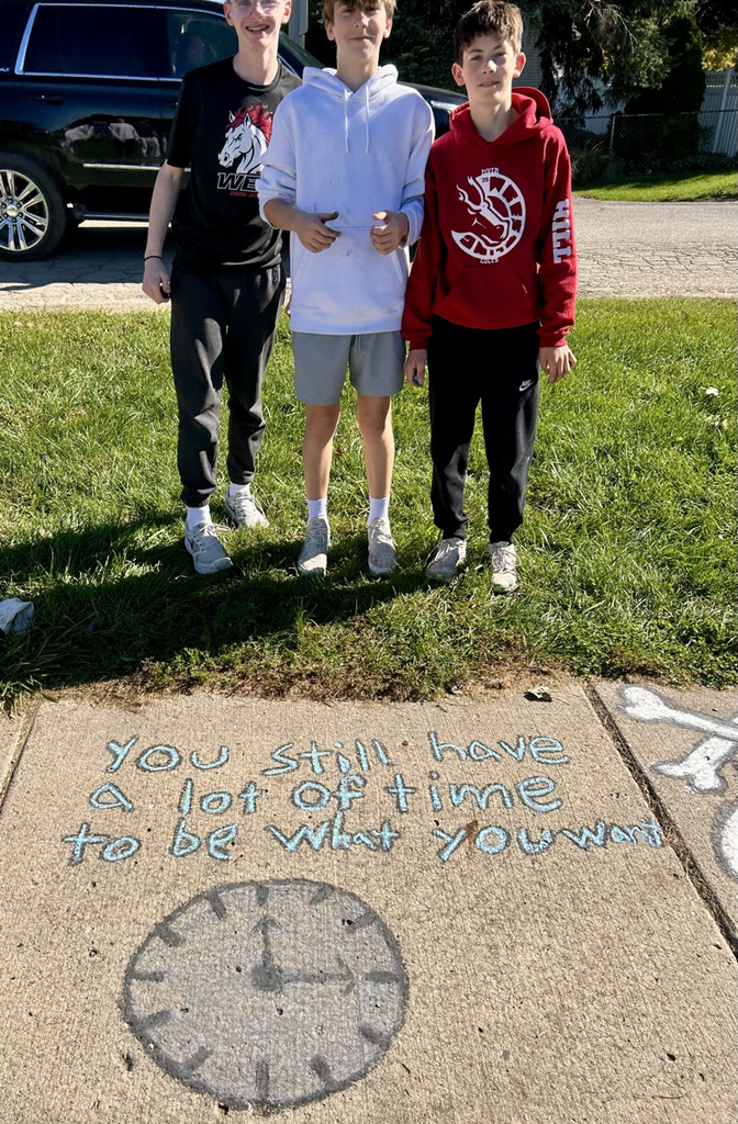 students stand near their chalk drawing outside Muir