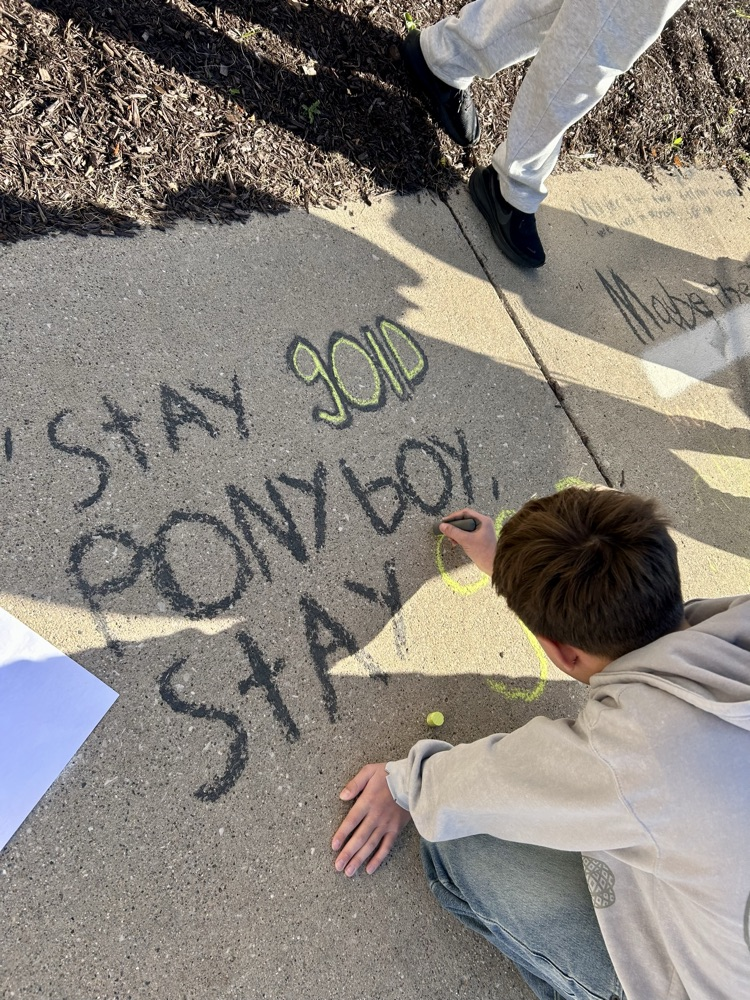 students stand near their chalk drawing outside Muir