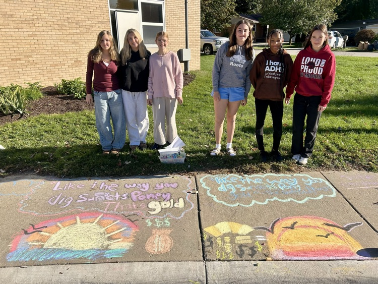 students stand near their chalk drawing outside Muir
