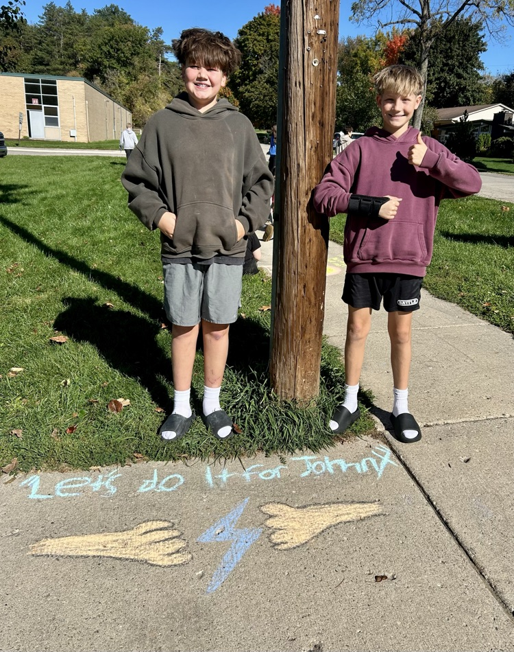 students stand near their chalk drawing outside Muir
