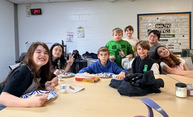 students sit at a table with their snack