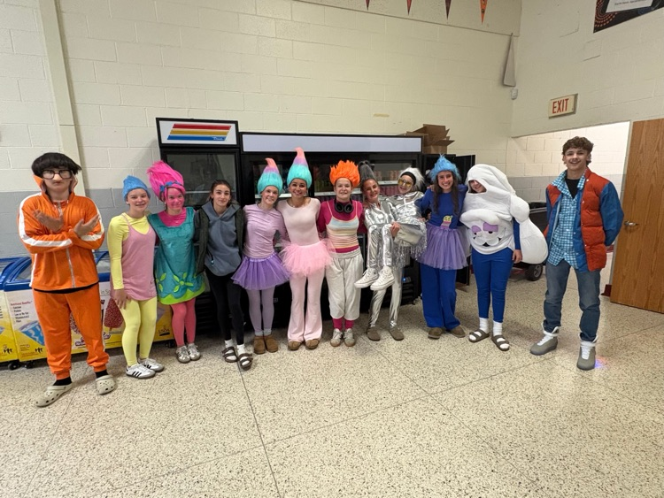 students stand in a group wearing costumes 