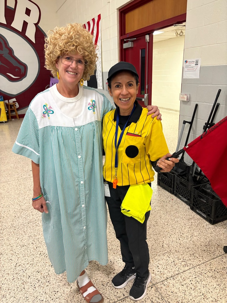 two teachers smile in their costumes 