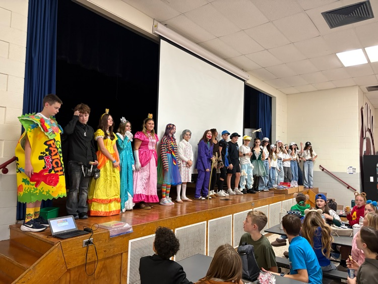 students stand on stage for the costume contest 