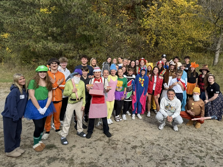 a group of students stand outside in costumes 