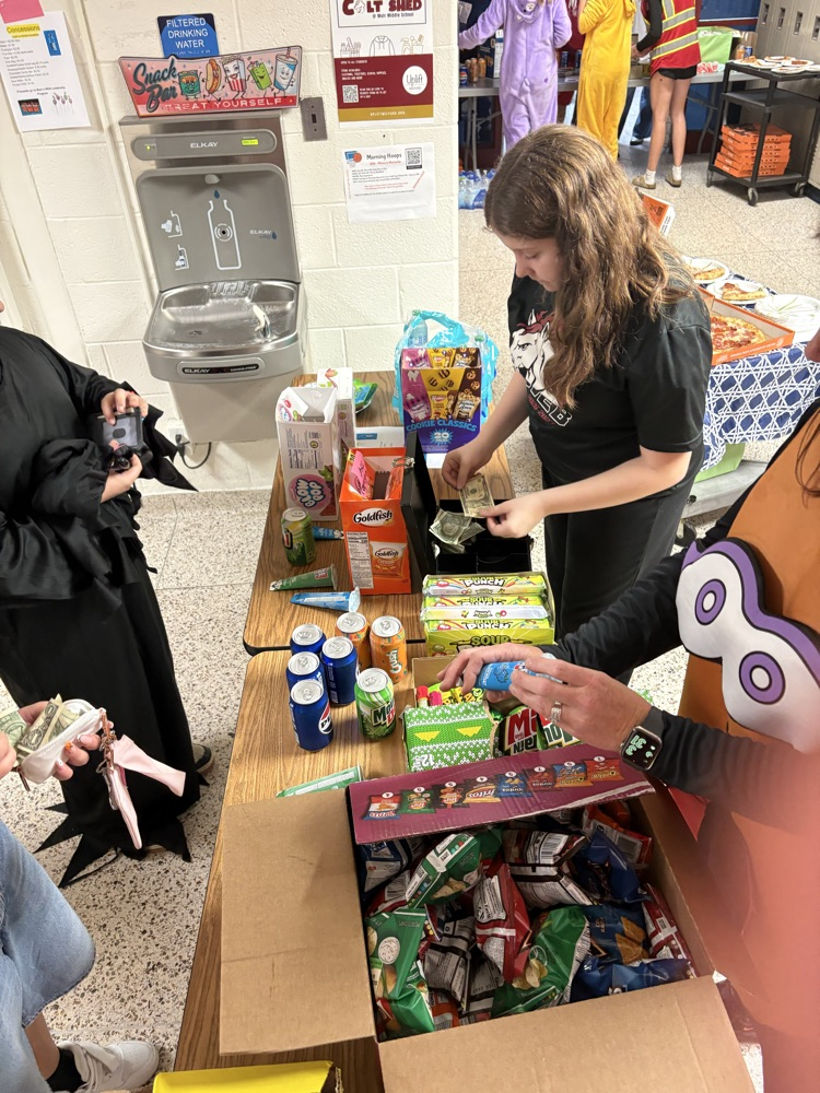 students selling concessions to students attending the Halloween party