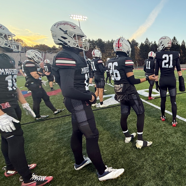 photo of football field with team warming up 