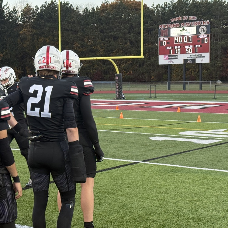 photo of football field with team warming up 