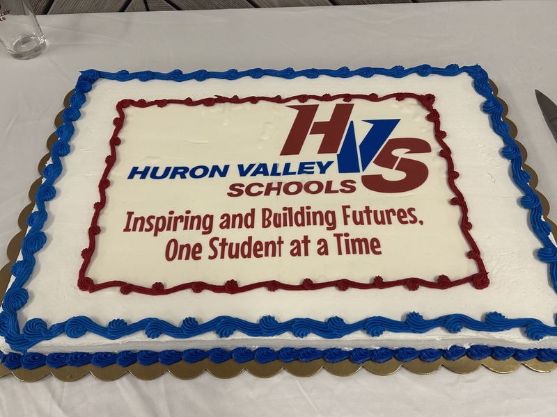photo of cake with blue red HVS logo and the words.. inspiring & building futures one student at a time