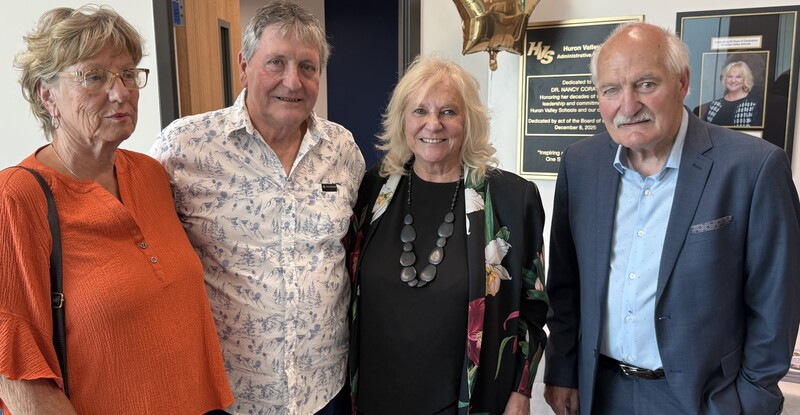 Dr. Coratti posing for photo in front of her plaque with three other people.