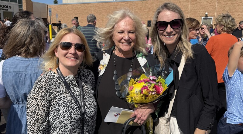 Dr. Coratti posing for photo in front of her plaque with two other people.